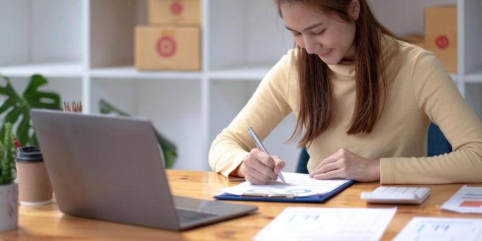 Portrait of Starting small businesses SME owners female entrepreneurs working, box and check online orders to prepare to pack the boxes, sell to customers, sme business ideas online..