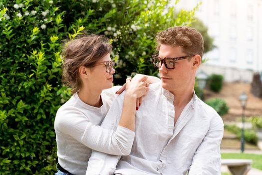 Young beautiful hipster couple in love sitting on old city park, summer Europe vacation, travel, fun, sunglasses, trendy outfit, romance, date, embracing