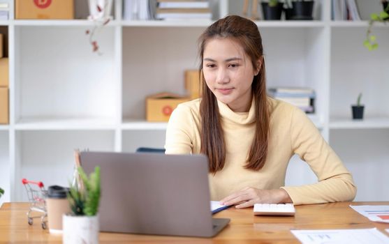 Portrait of Starting small businesses owners female entrepreneurs working on receipt box and check online orders to prepare to pack the boxes, sell to customers, sme business ideas online..