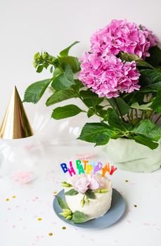 Very beautiful bright bento cake, decorated with fresh eustoma flowers against the background of sweets and the inscription happy birthday, balloons, pink flowers. The concept of holiday and smiles