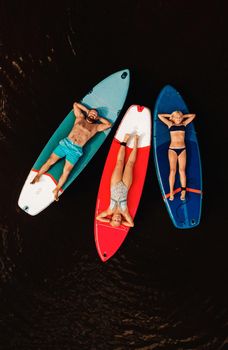 Family spend time together relaxing on sup boards on the lake.