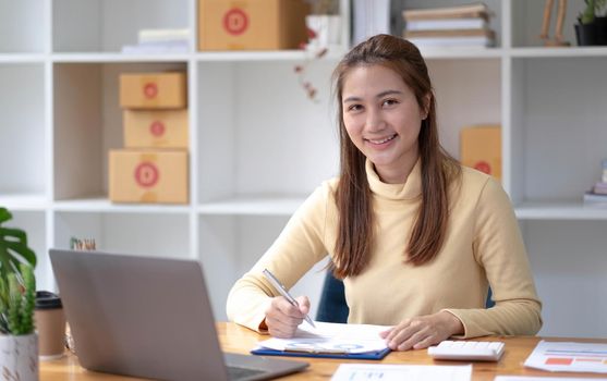 Small business entrepreneur SME freelance,Portrait of young asian woman working at home office,online marketing packaging delivery box,e-commerce business concept..