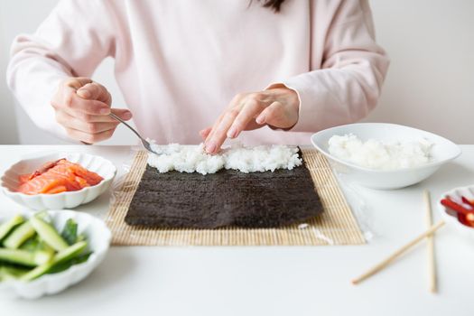 Sushi cooking process, girl makes sushi with different flavors