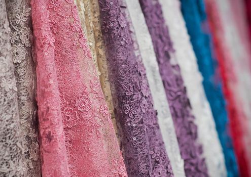 colorful fabric lace fabric rolls in textile shop industry.Rolls of bright colored fabric