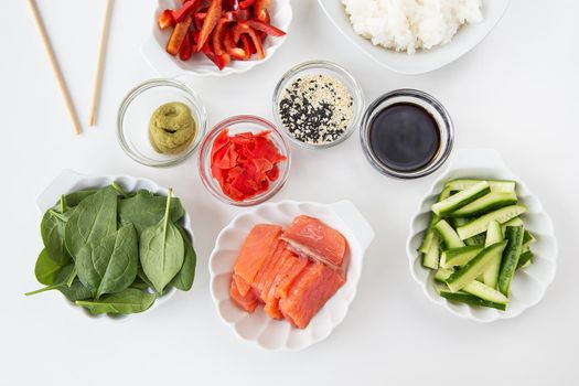 Sushi preparation process, preparation of all ingredients for sushi rice, salmon, pepper, sesame seeds, sauce, wasabi, ginger. View from above