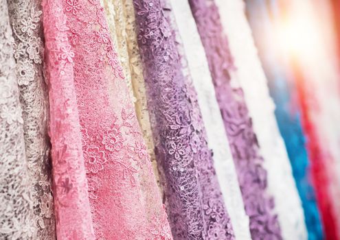 colorful fabric lace fabric rolls in textile shop industry. Rolls of bright colored fabric