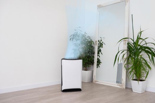 Air purifier in cozy white living room for filter and cleaning removing dust PM2.5 HEPA and virus in home, for fresh air and healthy Wellness life, Air Pollution Concept.