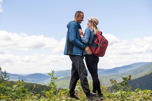 Portrait of beautiful young couple enjoying nature at mountain peak