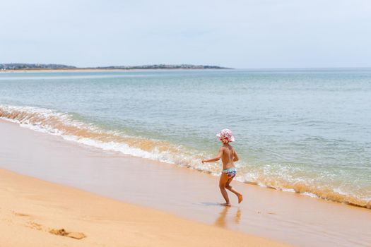 Back view of adorable little girl at sandy Atlantic ocean beach during summer. High quality FullHD footage