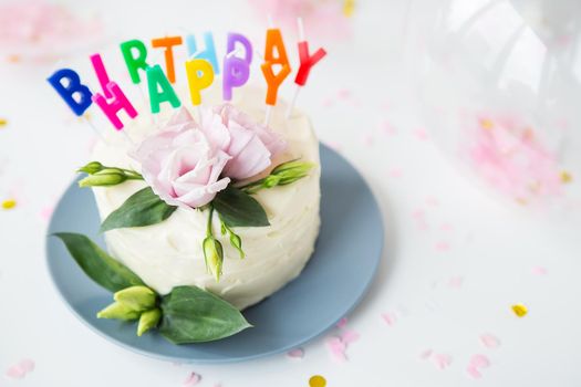 Very beautiful bright bento cake, decorated with fresh eustoma flowers against the background of sweets and the inscription happy birthday, balloons. The concept of holiday and smiles