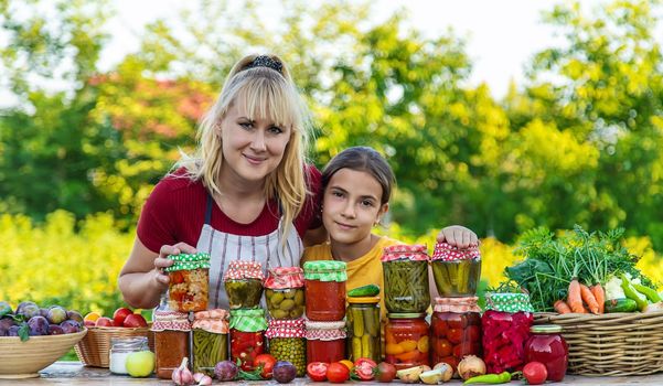 Woman with jar preserved vegetables for winter mother and daughter. Selective focus. Food.