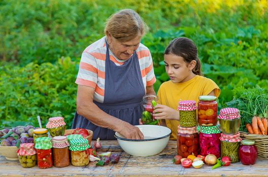 Women with jar preserved vegetables for the winter mother and daughter. Selective focus. Food.