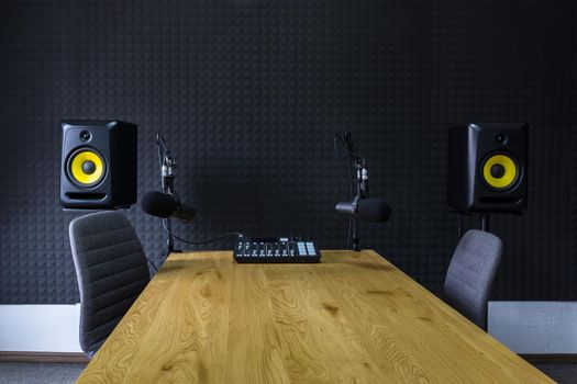 Podcast recording studio, with microphones and equalizer for recording online radio broadcasts, with black soundproof wall