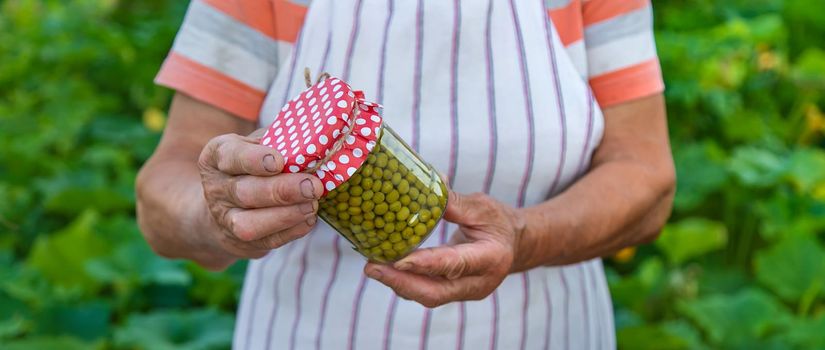 Senior woman preserving vegetables in jars. Selective focus. Food.