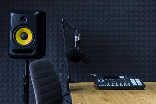 Podcast recording studio, with microphones and equalizer for recording online radio broadcasts, with black soundproof wall