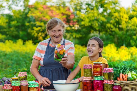 Women with jar preserved vegetables for the winter mother and daughter. Selective focus. Food.