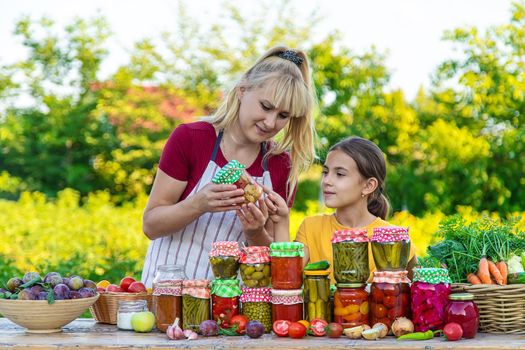 Woman with jar preserved vegetables for winter mother and daughter. Selective focus. Food.