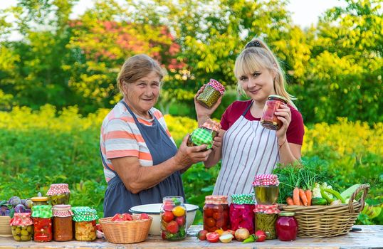 Women with jar preserved vegetables for the winter mother and daughter. Selective focus. Food.