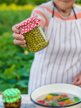 Senior woman preserving vegetables in jars. Selective focus. Food.