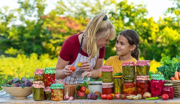 Woman with jar preserved vegetables for winter mother and daughter. Selective focus. Food.