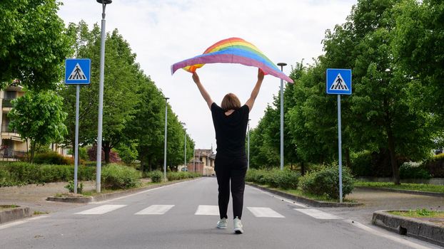 Bisexual, lesbian, female, transgender walk with LGBT flag on the road, walk on a sunny day and celebrate Bisexuality Day or National Coming Out Day