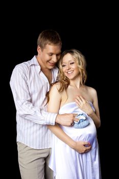 Young couple tall man and blond pregnant woman wait boy with blue baby's bootee