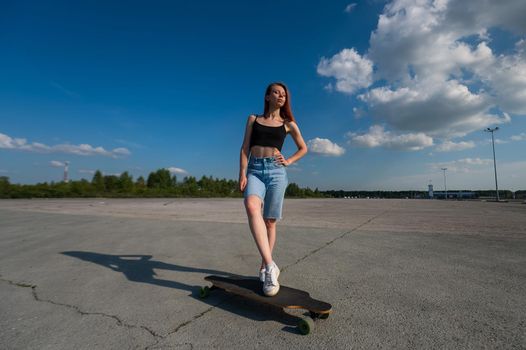 Young caucasian woman riding a longboard outdoors