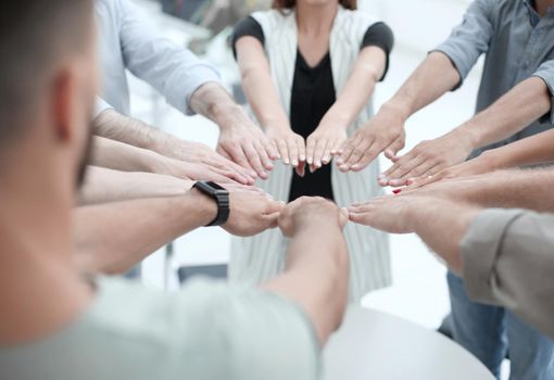 close up.young business team forming a circle of hands . the concept of team building