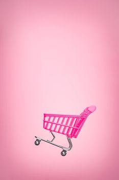 Empty trolley cart isolated pink background. Pink shopping trolley supermarket concept. Toy pink concept sales online shopping cart supermarket sales shopping symbol. Sale cart shop online. E commerce