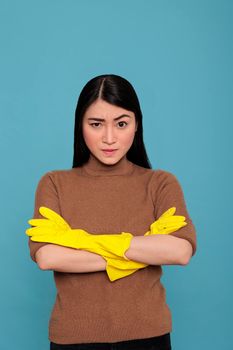 Asian tired angry and frustrated asian housekeeper at work wearing yellow glove against a blue background, Housewife worker, Cleaning home concept, Unhappy stressed and overworked woman