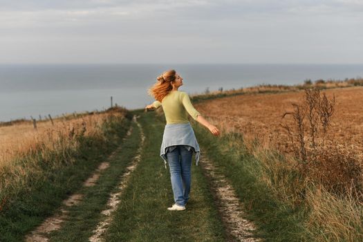Woman whirls on and relaxes in nature near field