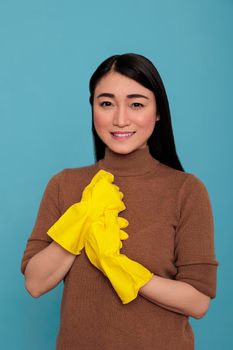 Adult glad satisfied asian housewife from work holding hand wearing rubber yellow gloves, Cleaning home concept, Happy optimistic and smiling woman with positive state of mind