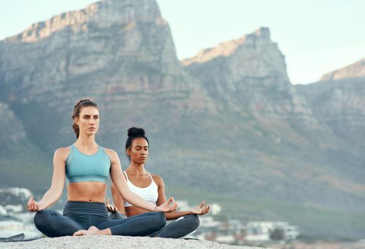 Yoga is a way to call for calm. two sporty young woman practicing yoga together outdoors