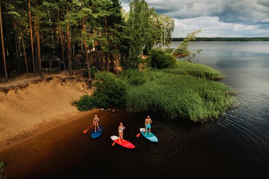 The family spends time together swimming on sup boards on the lake.