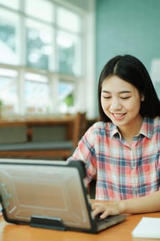 Young asian woman student study at offsite. Her using laptop and learning online.