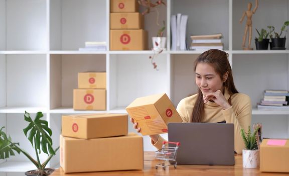 Portrait of Starting small businesses SME owners female entrepreneurs working on receipt box and check online orders to prepare to pack the boxes, sell to customers, sme business ideas online..