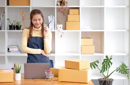 Portrait of Starting small businesses SME owners female entrepreneurs working on receipt box and check online orders to prepare to pack the boxes, sell to customers, sme business ideas online..