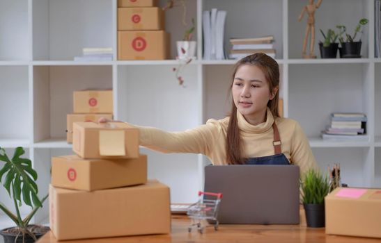 Portrait of Starting small businesses SME owners female entrepreneurs working on receipt box and check online orders to prepare to pack the boxes, sell to customers, sme business ideas online..