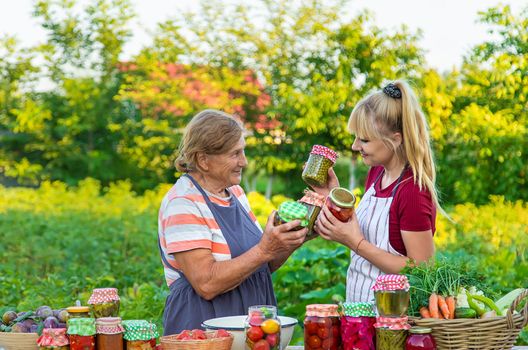 Women with jar preserved vegetables for the winter mother and daughter. Selective focus. Food.