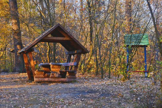 an outing or occasion that involves taking a packed meal to be eaten outdoors. Autumn picnic. Wooden gazebo house in a forest clearing for recreation camping. High quality photo