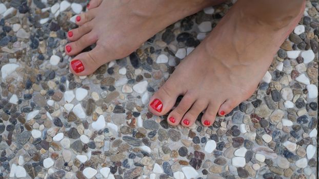 Woman bare feet stand on stone tile floor. Stone trendy tiles concept