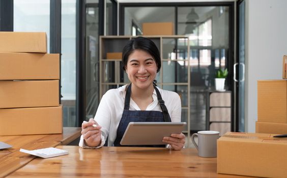 Portrait asian small business entrepreneur SME working with box at home, SME e-commerce digital technology concept