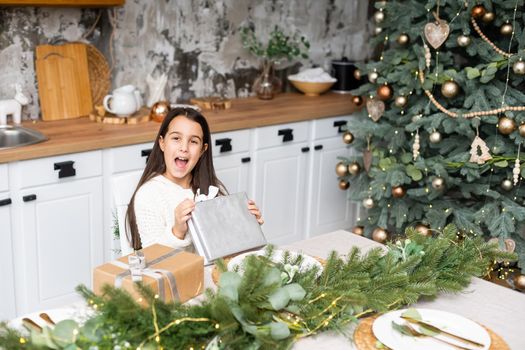 Happy little smiling girl with christmas gift box