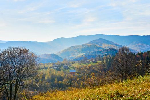 a large natural elevation of the earths surface rising abruptly from the surrounding level, a large steep hill. Distant mountains with blue haze framed by autumn grass. High quality photo