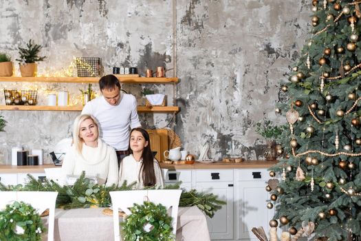 family, christmas, x-mas, winter, happiness and people concept - smiling family Preparing to celebrate Christmas