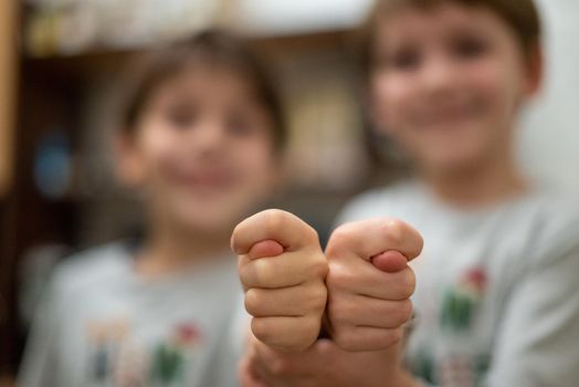 Two boys show fig sign. Home background. concept human behavior. emotional, funny.