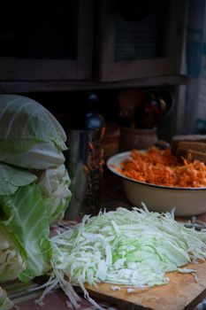 Cut cabbage on wooden board for babbage sauerkraut in old farm kitchen, selective focus