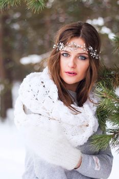 Beautiful bride in a white dress with a bouquet in a snow-covered winter forest. Portrait of the bride in nature.Beautiful bride in a white dress with a bouquet in a snow-covered winter forest. Portrait of the bride in nature.