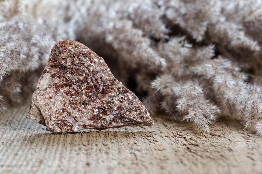 Alurgite is a variety of Muscovite mineral stone. Closeup of rough crystal formation on rock. Crystal healing therapy