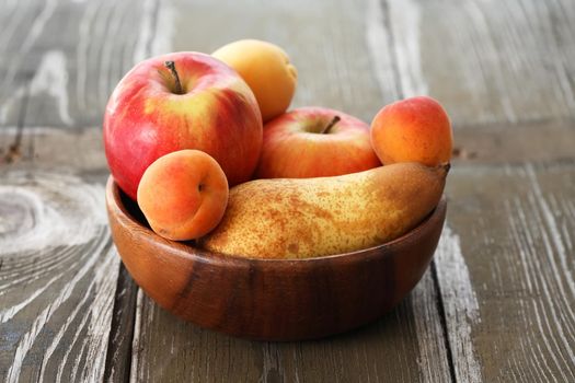 Heap of freshness fruits in  bowl on old wooden table